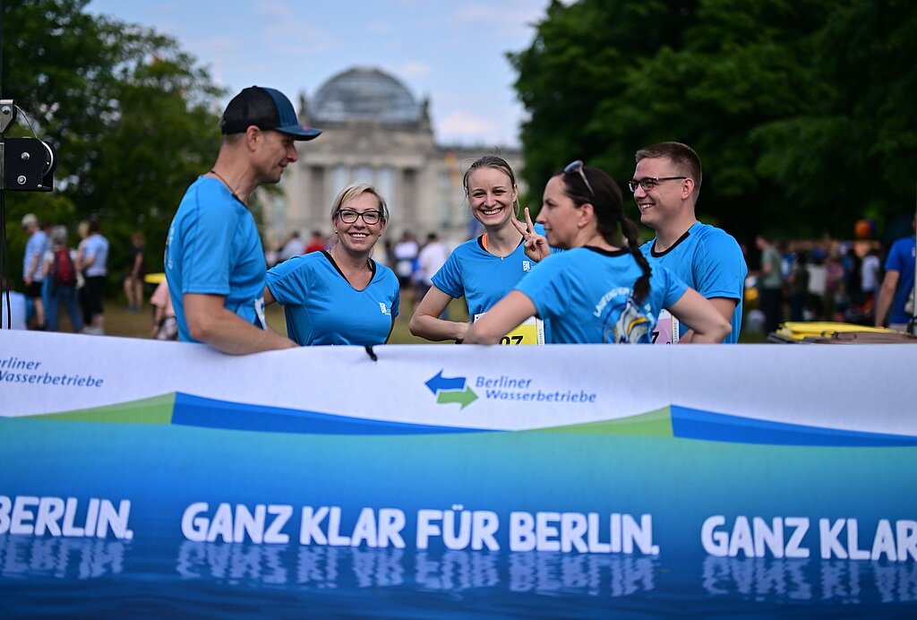Teilnehmergruppe vor dem Banner der Berliner Wasserbetriebe, im Hintergrund der Reichstag © SCC EVENTS / Petko Beier