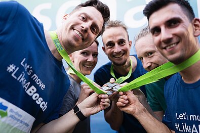 5x5 TEAM STAFFEL: Alle Teammitglieder halten ihre Medaillen zusammen © SCC EVENTS / Sebastian Wells 