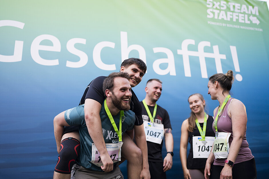Staffel-Team vor Banner mit Aufschrift "Geschafft".